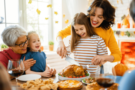 family carving turkey with kids