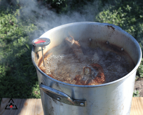 boiling turkey fryer with thermometer on the side.