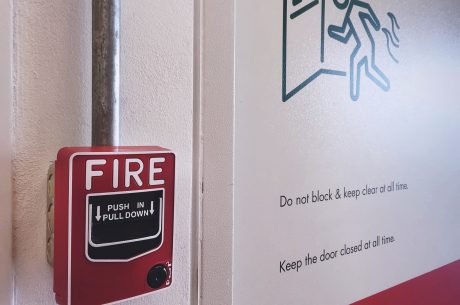 Close-up of red fire alarm box near an emergency exit