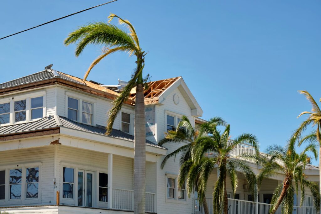 Damaged house roof with missing shingles after hurricane