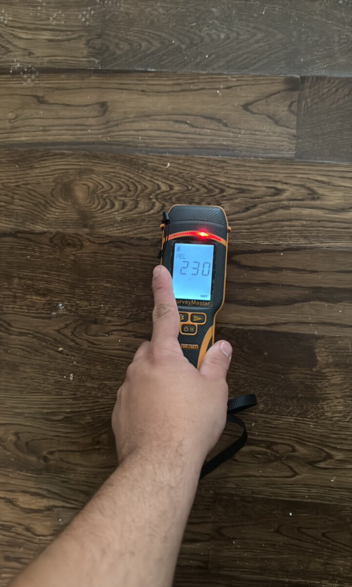 Moisture meter checking wood flooring after water damage