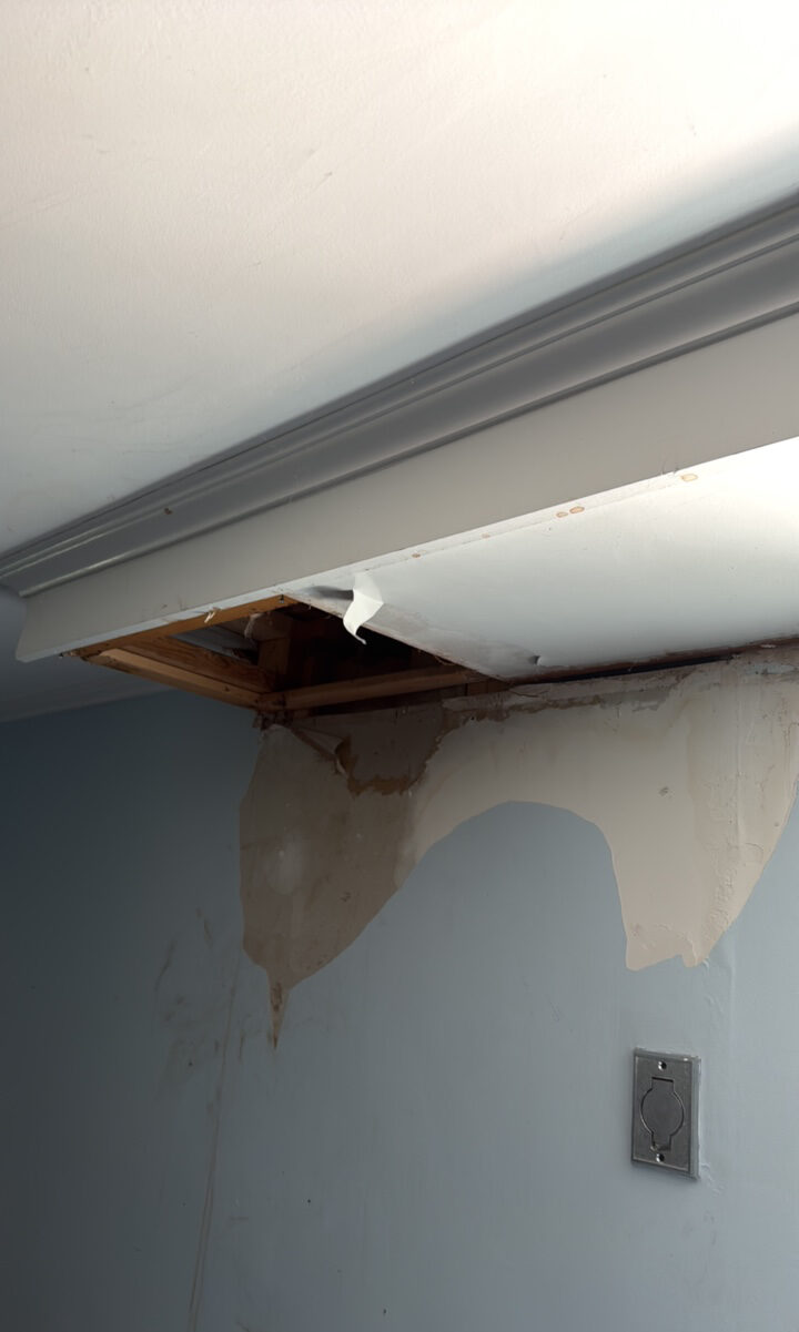 Water-damaged ceiling and wall with exposed framing