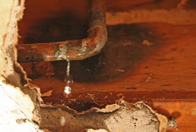 water damage in multi-unit buildings can start with a corroded pipe like this one leaking behind walls, under floors or above ceilings