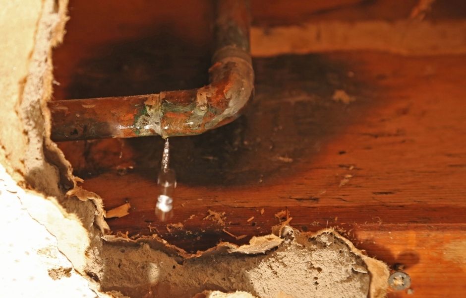 water damage in multi-unit buildings can start with a corroded pipe like this one leaking behind walls, under floors or above ceilings