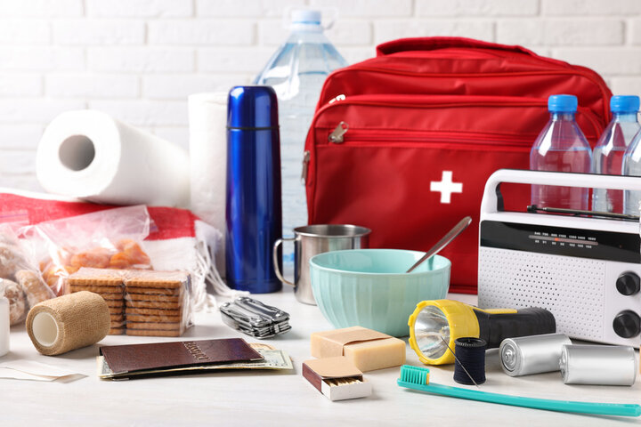 An emergency kit containing non-perishables, bottled water, and a first aid kit.