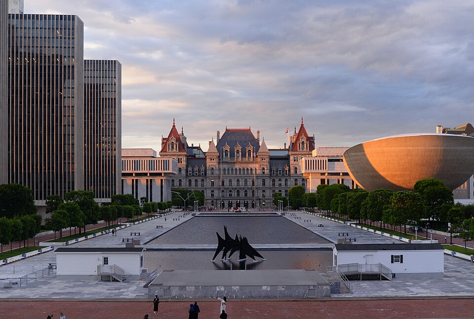 Empire State Plaza at sunset featuring the historic Capitol, modern buildings, and The Egg. TITLE