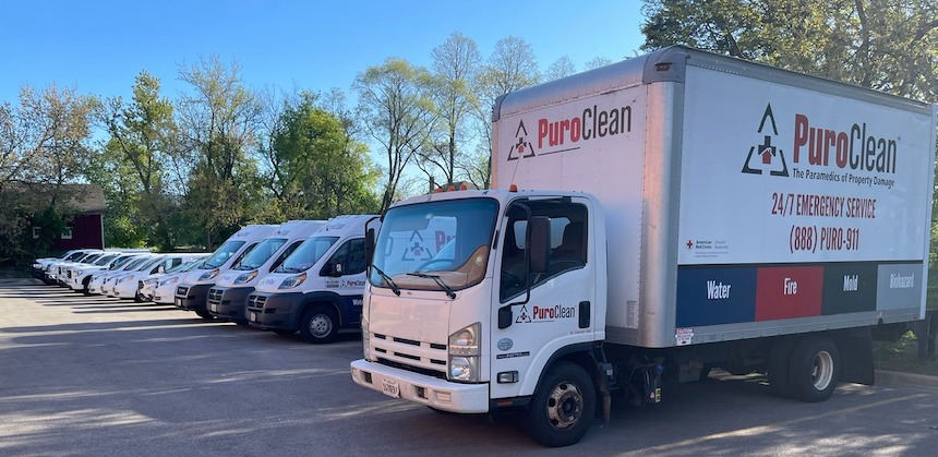 Fleet of PuroClean Disaster Services vehicles, including a large emergency response truck, ready to provide emergency basement water removal, fire damage restoration, mold remediation, and biohazard cleanup.