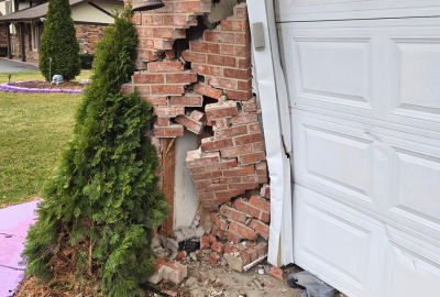Structural damage to a brick garage corner after vehicle impact, requiring professional reconstruction and repair services by PuroClean of Orland Park.