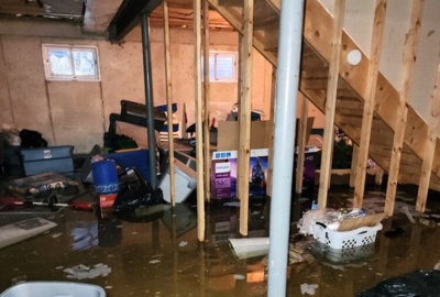 Basement with severe flooding, standing water, and damaged personal items—emergency basement water removal in Orland Park needed.