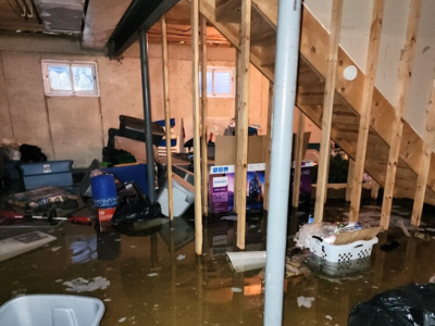 Basement with severe flooding, standing water, and damaged personal items—emergency basement water removal in Orland Park needed.