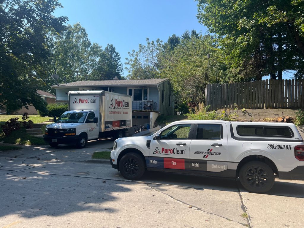 PuroClean emergency response vehicles parked outside a residential home during a property damage restoration and reconstruction services project.