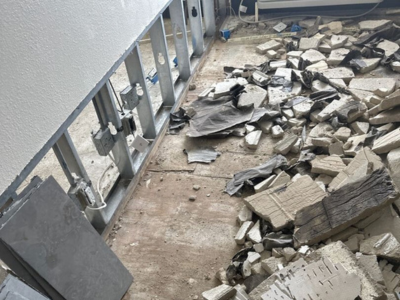 Fire damage restoration in Orland Park showing tile debris, exposed framing, and post-fire demolition cleanup in progress.