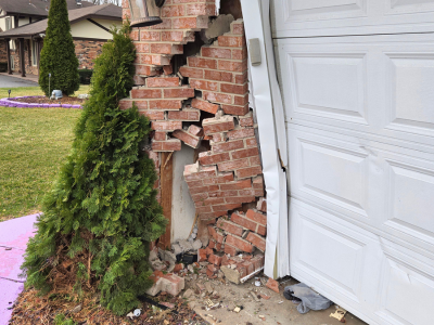 Structural damage to a brick garage corner after vehicle impact, requiring professional reconstruction and repair services by PuroClean of Orland Park.