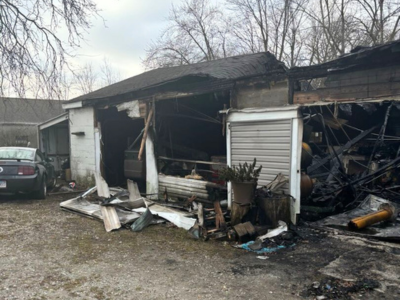 Structural fire damage visible in a burned and partially collapsed garage in Orland Park, with exposed framing and debris.