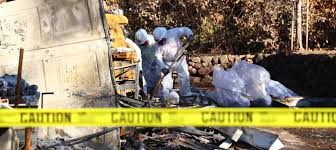 Technician wearing protective gear preparing disinfectants for a biohazard cleanup