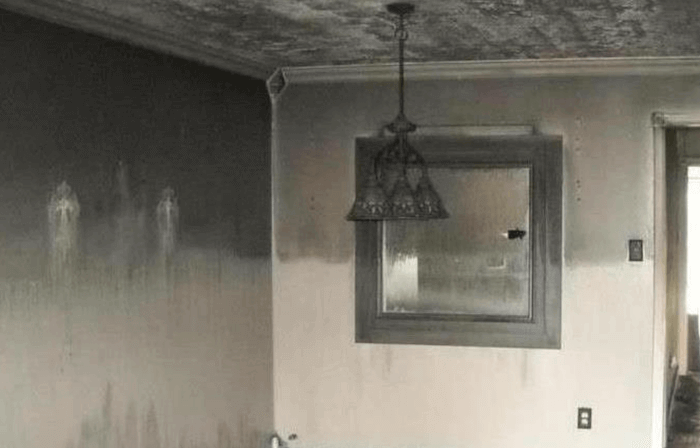Smoke damage visible on walls and ceiling following a small fire in a residential kitchen