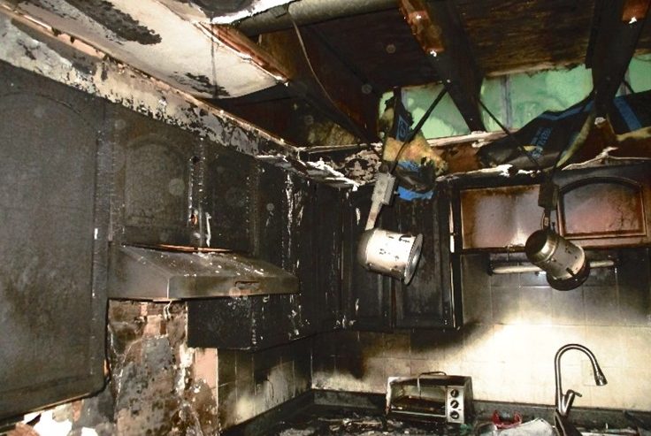 Smoke-stained ceiling and walls inside a home after a small kitchen fire
