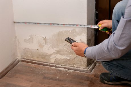Man inspecting water damaged walls.
