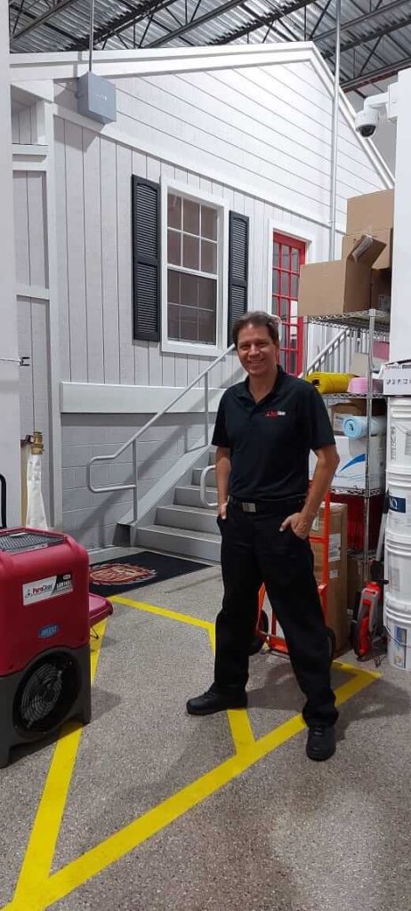Professional Carlos Niemes standing with the equipments smoke restoration company 1