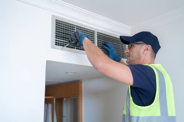 Air Duct Cleaning in Plantation: Repairman Cleaning Air Conditioning Wall Mounted Ventilation System On Ceiling In Hotel Room