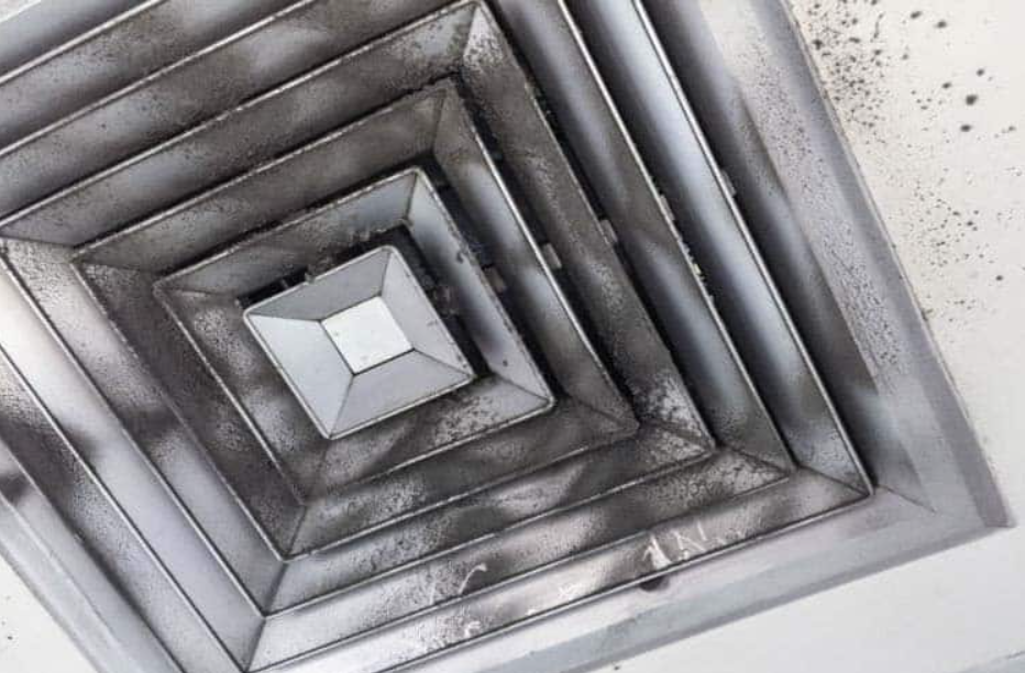 Soot buildup inside HVAC duct requiring smoke damage cleanup services after fire