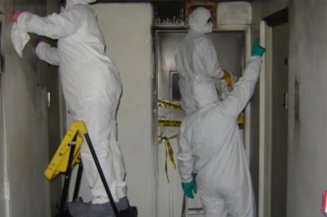 fire damage restoration cost breakdown; professional crew assessing smoke and soot damage in a residential home