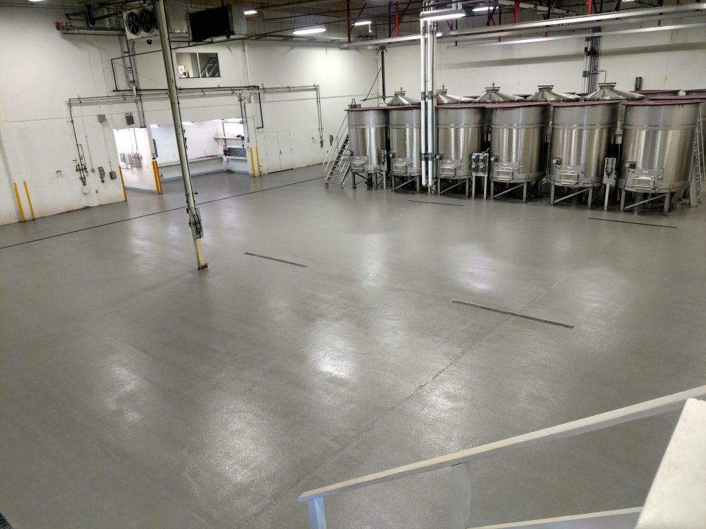 Water extraction and restoration work on epoxy coated concrete flooring inside a Rancho Cucamonga CA winery production facility after a water damage event