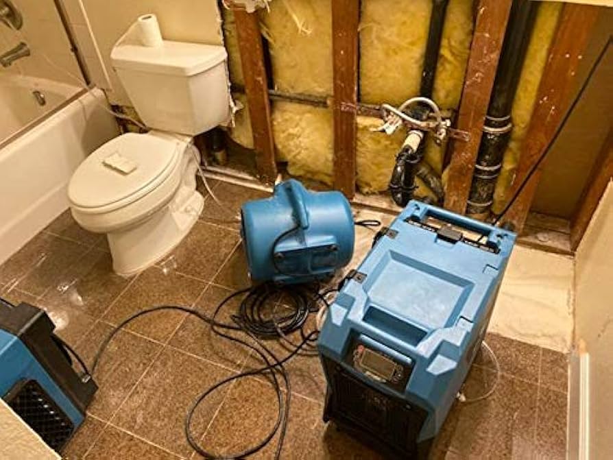 professional water mitigation equipment air movers and dehumidifiers set up in home