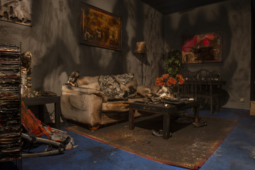 fire‑damaged living room interior with debris and burned furniture