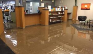 Water damage restoration service team assessing flooded medical office interior in Rancho Cucamonga CA requiring specialized compliance-aware restoration response