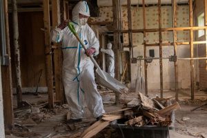 Professional fire damage restoration team in protective gear assessing a damaged interior in a Ridgewood, NJ home.