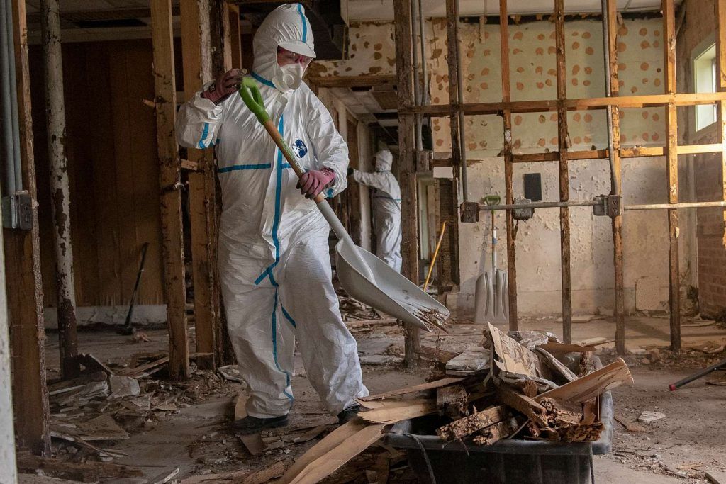 Professional fire damage restoration team in protective gear assessing a damaged interior in a Ridgewood, NJ home.