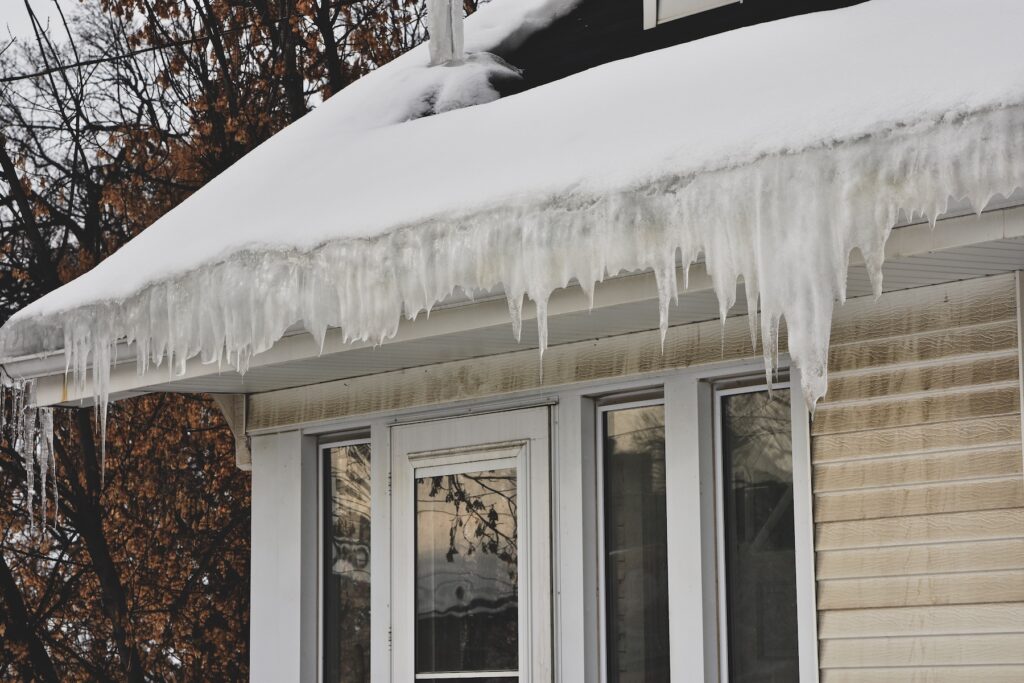 Ice dam formation on the roof of an older Bergen County NJ home causing water intrusion and ceiling damage during a winter Nor'easter storm