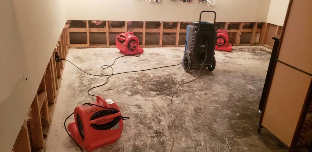 Professional water damage restoration technician using moisture detection equipment inside wall cavity of an older Ridgewood NJ home after pipe failure
