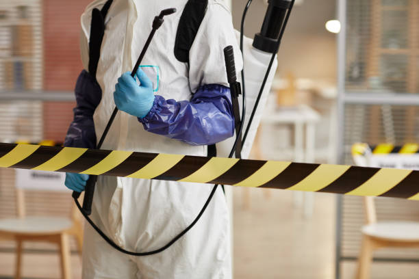 Cropped portrait of unrecognizable disinfection worker wearing full protective gear standing behind danger line while Biohazard Cleanup in Emerson