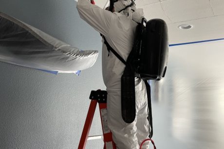 A technician inspecting the water damage from a water heater leak.