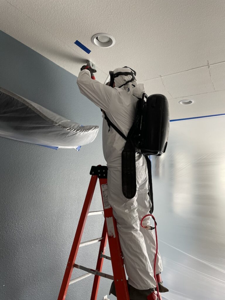 A technician inspecting the water damage from a water heater leak.