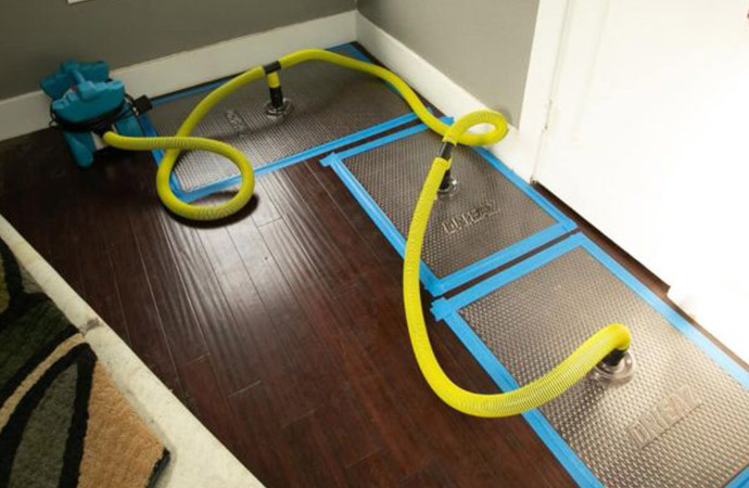 technician drying a water-damaged floor in a Siesta Key beachfront home