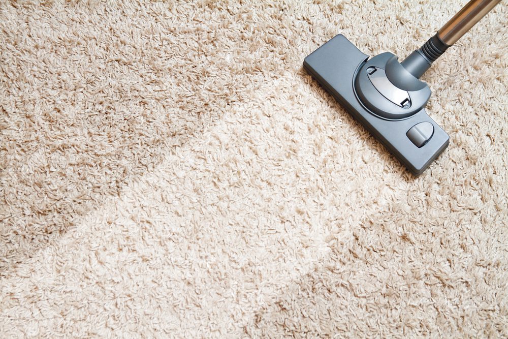 Running a vacuum over a carpet