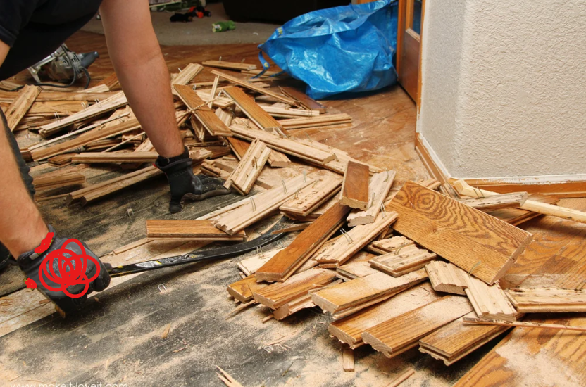 how to fix warped wood floor from water ; contractor removing buckled hardwood boards for replacement