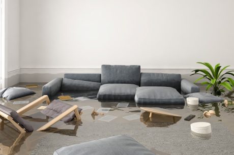 couch and chairs in flooded living room. Spring flooding prevention can help you avoid this scenario,