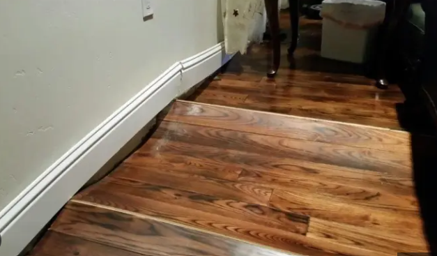 water damage floor repair cost Montgomery County PA; contractor assessing water-damaged hardwood