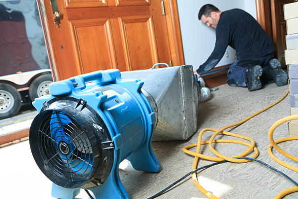 Water damage restoration in Schwenksville professional technician extracting water