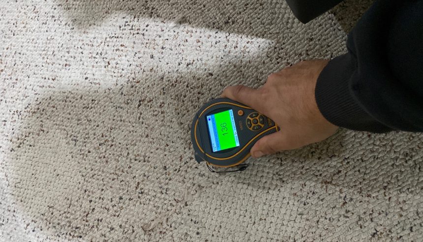 A man using a Water damage Detection device