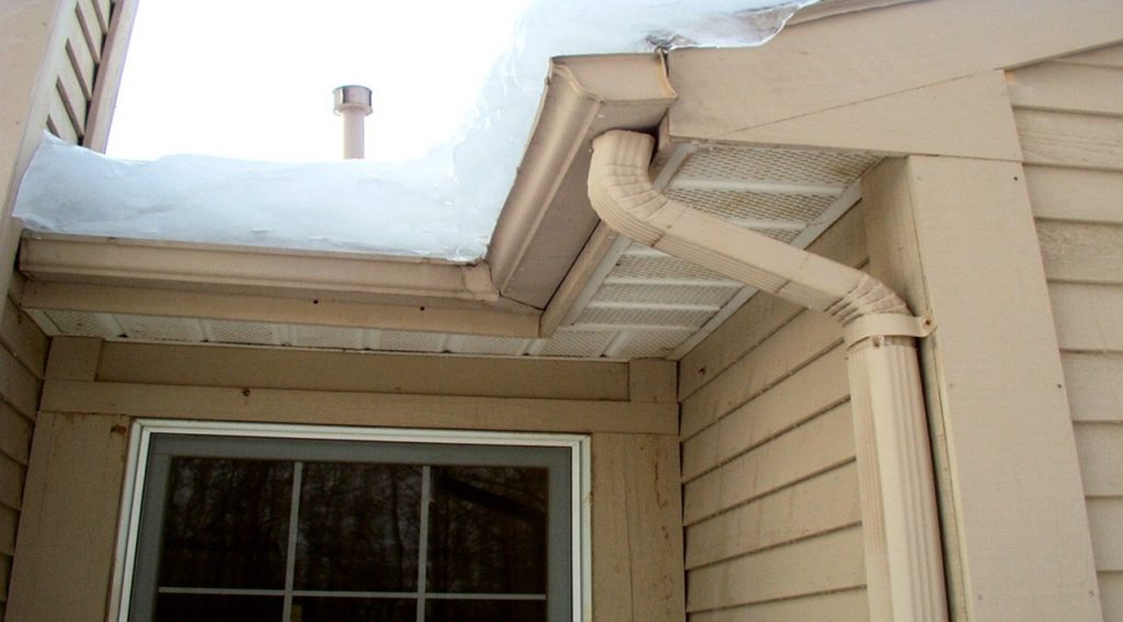 “Ice dam buildup along a roof edge and gutter, blocking drainage and increasing the risk of water damage.”