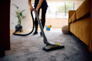 Close up of woman vacuuming while working professional Carpet cleaning services in Nassau County
