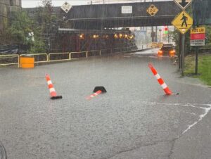 Flooded railroad underpass in downtown Stamford during the September 13, 2026 flash flood, traffic cones half submerged in standing water