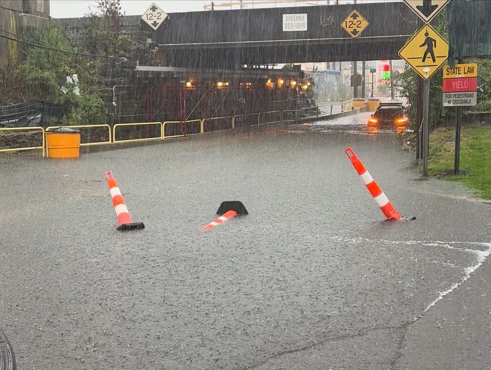 Flooded railroad underpass in downtown Stamford during the September 13, 2026 flash flood, traffic cones half submerged in standing water