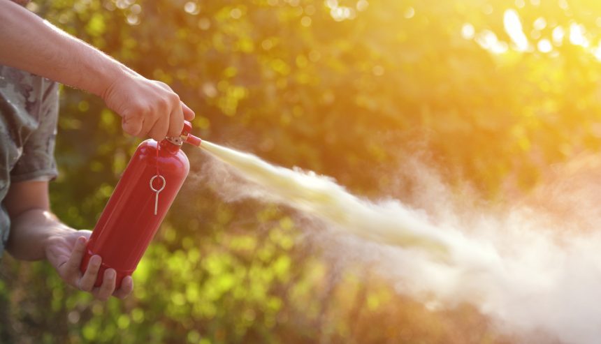 A man demonstrating how to use a fire extinguisher