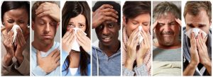 A row of diverse people side-by-side, each showing symptoms of illness like sneezing and headaches.